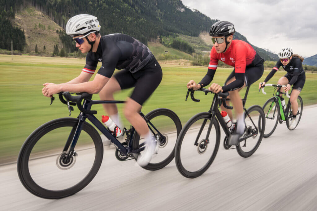 Drie racefietsers onderweg op Alpenwegen in de racefietsuitdaging rond Saalfelden